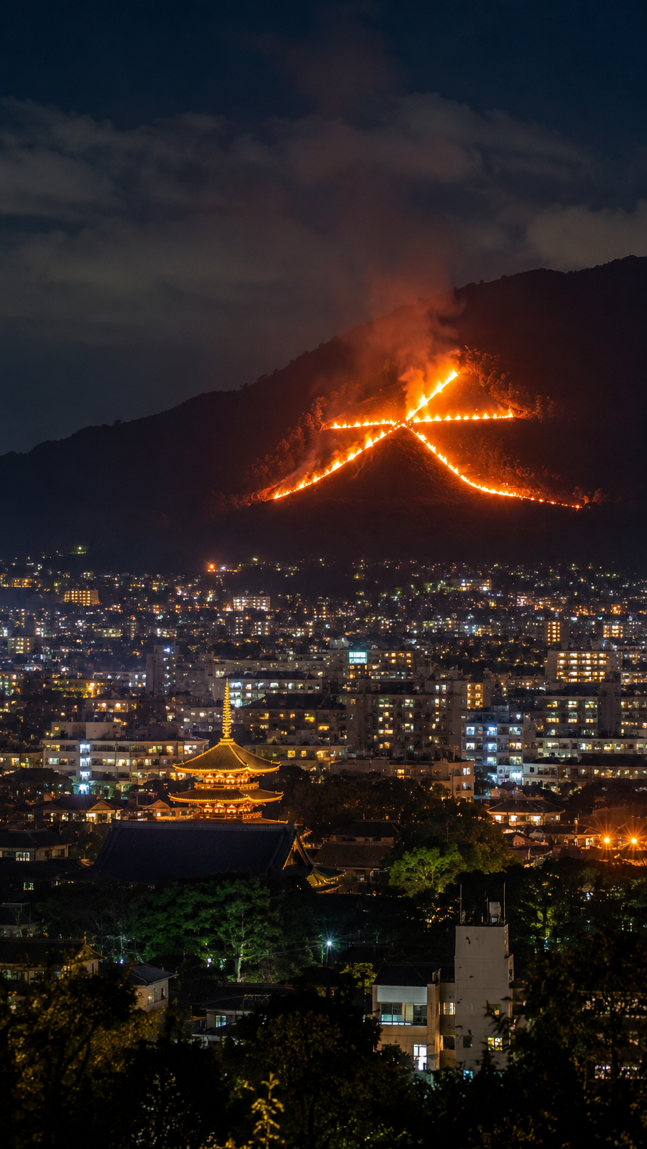 京都の夏の夜に山肌へ大文字の炎が浮かび上がり京都市街を照らす五山送り火の風景