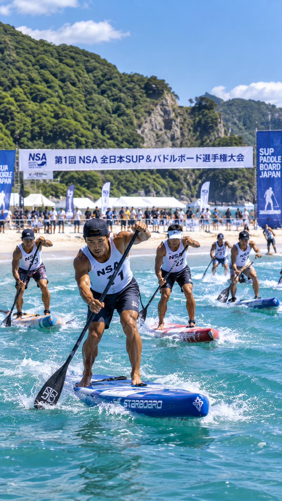 静岡県下田市の白浜大浜海岸で第1回NSA全日本SUP＆パドルボード選手権大会が開催され、選手たちがSUPボードに乗ってパドルを漕ぎながら海上で競い合う大会の風景