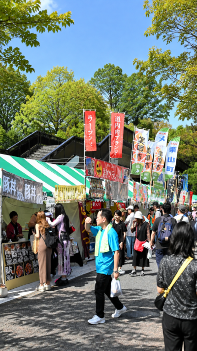 東京都渋谷区の代々木公園で北海道フェアが開催され、北海道グルメの屋台や飲食ブースに多くの来場者が集まる秋の食イベント風景