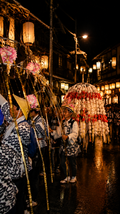 長野県野沢温泉村の夜の温泉街で灯籠が並び、湯澤神社例祭の伝統行事が幻想的な光に包まれる風景