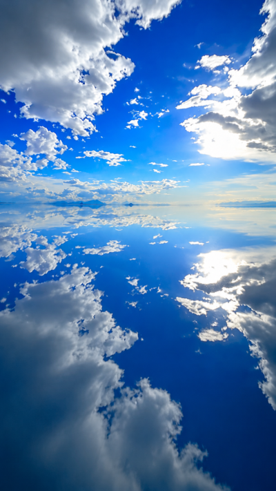 ボリビアのウユニ塩湖で薄い水面が空と星を反射し、地平線まで続く幻想的な天空の鏡の風景