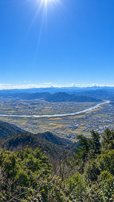 出雲平野の広大な田園と北山山系を背景に大学駅伝のランナーたちが駆け抜ける出雲駅伝の風景