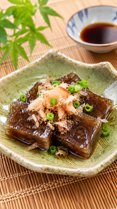 茨城県の郷土料理海藻よせを食べやすい大きさに切り、醤油や薬味を添えて和食器に盛り付けた料理