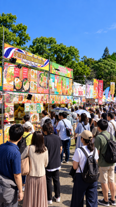 山下公園に世界各国の料理を提供する屋台が並び、多くの来場者で賑わうワールドフェスタ・ヨコハマ2026の会場風景